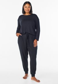 Zwart loungewear-set met een long-sleeve top met een ronde hals en joggerpants met een verstelbare trekkoord taille. Soepele textuur.