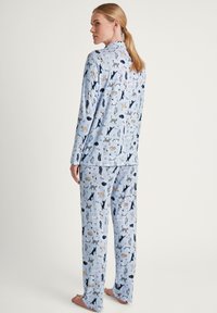 Helles blaues Schlafanzugset mit verschiedenen bedruckten Tieren. Langärmliges Oberteil und passende Hose mit lockerem Schnitt und weichem Stoffgefühl.