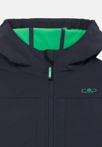Giacca softshell color navy con cappuccio foderato in pile verde, cerniera frontale e un piccolo logo verde. Presenta cuciture a contrasto e polsini elasticizzati.