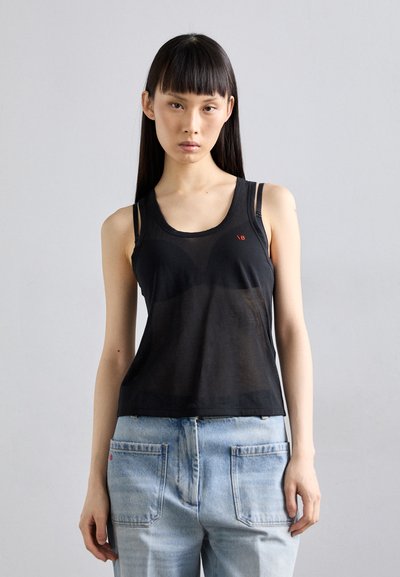 Sort gennemsigtig tanktop med rund halsudskæring og smalle stropper. Har et lille rødt logo på forsiden og en afslappet pasform, parret med lyseblå jeans.