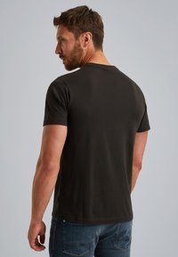 Camiseta de manga corta gris oscuro con cuello redondo clásico y una pequeña etiqueta con el logo en el dobladillo, hecha de un suave material de algodón.