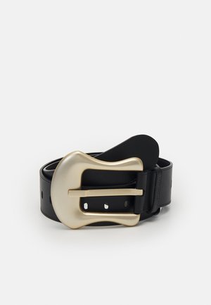 Ceinture en cuir noir avec une grande boucle incurvée mate en or, enroulée à plat sur un fond blanc.