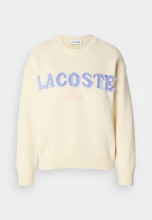 Cremefarbener Pullover mit Rundhalsausschnitt, gerippten Bündchen und Saum. "LACOSTE" in flauschigen blauen Buchstaben und "Paris" in sanftem Pink zentriert auf der Vorderseite.