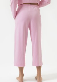 Lichtroze cropped broek gemaakt van zachte katoen, met een elastische tailleband en zijzakken. Soepele textuur met nette naden.