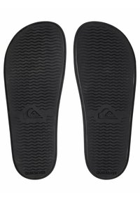 Sottopiedi in gomma nera con superficie texturizzata, caratterizzati da motivi a onde e dal logo Quiksilver; bordi arrotondati e design piatto.