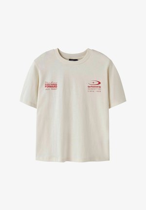 Kremowa koszulka z krótkim rękawem wykonana z bawełny, z czerwonym nadrukowanym tekstem i detalami na przodzie. Luźny krój z okrągłym dekoltem.