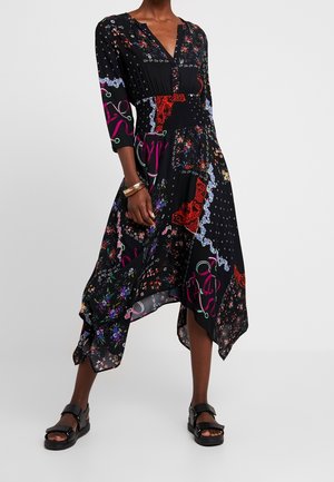 Schwarzes Midikleid mit Blumenmuster und asymmetrischem Saum, V-Ausschnitt, dreiviertel Ärmeln, geraffter Taille, kombiniert mit schwarzen Sandalen und einem goldenen Armband.