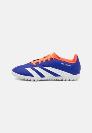 Zapatillas deportivas azules con rayas blancas, cordones naranjas y parte superior sintética texturizada; diseñadas para tracción con una suela de goma.