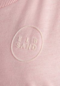 Roze sweatshirt met een zachte textuur en een ronde, geborduurde logo dat "ELB SAND" in lichte draad laat lezen.