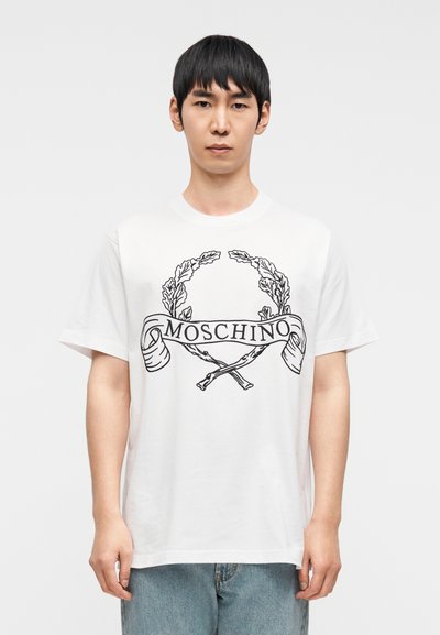 Λευκό βαμβακερό T-shirt με μαύρο γραφικό σχέδιο από φύλλα δάφνης και σταυρωμένα όπλα, με το κείμενο "MOSCHINO" στο κέντρο.