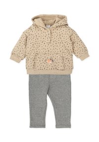 Sudadera beige con pequeños cuadrados grises, bolsillo frontal con aplicación de zorro, combinada con leggings grises de una tela suave y elástica.