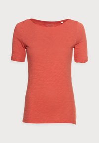 Kortærmet, rundhalset shirt i tekstureret koralfarvet stof. Har en afslappet pasform og en subtil variation i farven gennem materialet.