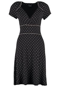 Robe noire à manches courtes avec des pois blancs, corsage croisé en V et surpiqûres blanches décoratives à la taille et aux épaules.