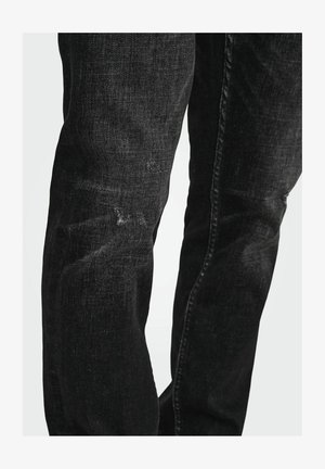 Jean en denim noir avec une coupe droite, un léger délavage et des détails usés au niveau des genoux. Coutures piquées et design classique à cinq poches.