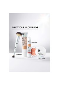 Neljän IT Cosmetics -tuotteen, joissa lukee Correct, Conceal ja Lift & Glow, linjassa valkoisella pinnalla vaaleanharmaan taustan edessä.