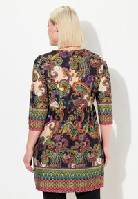 Kleurrijke tuniekjurk met paisleypatroon en een cinched taille, driekwart mouwen en een zwarte achtergrond. Bevat uitgebreide details aan de zoom.
