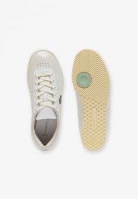 Białe skórzane sneakersy z gładką cholewką, teksturowanymi akcentami i gumową podeszwą z zielonym okrągłym detalem. W komplecie sznurowadła i perforowany wzór.