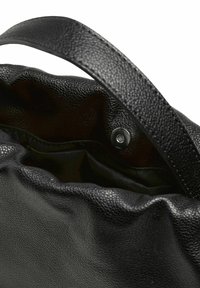 Černá kožená kabelka s texturovaným povrchem, s jedním uchem a vnitřním cvočkem pro bezpečné uložení.