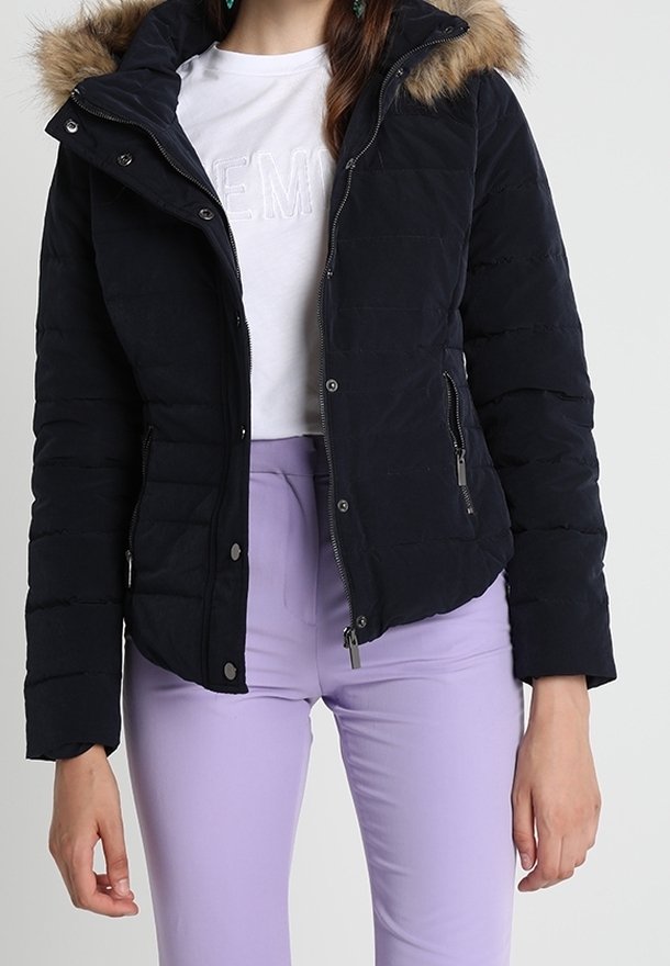 Tmavě námořnická péřová bunda s umělým kožíškem na kapuci, prošívanou texturou, zipovými kapsami a druky, kombinovaná s levandulovými kalhotami.