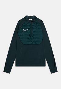 Sudadera de color verde oscuro con un zipper de cuarto. La sección frontal acolchada presenta un detalle de costura. Tela suave en las mangas y los lados. Logotipo de Nike exhibido.