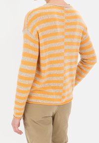 Gestreifter Pullover in Orange und Beige, mit einer Rückennaht, rundem Ausschnitt und langen Ärmeln, aus einem weichen Strickstoff gefertigt.