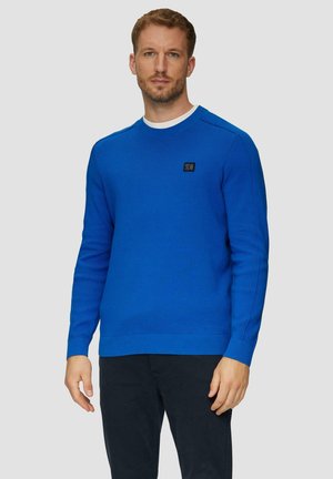 Blauwe gebreide trui met een ronde halslijn, geribbelde manchetten en zoom. Heeft een zwart logo-label op de borst. Glad textuur, aansluitend ontwerp.