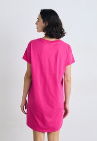 Kort rosa bomullskjole med rund hals og korte ermer, med en avslappet passform og lengde over kneet.