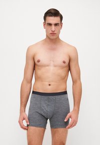Γκρι βαμβακερά μποξεράκια με σκούρα μέση, που διαθέτουν μια λεπτή υφή και λειτουργικό σχεδιασμό. Χωρίς ορατά σχέδια ή λογότυπα.