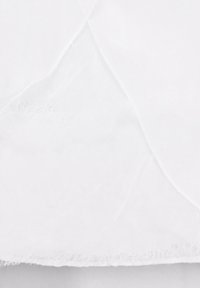 Hvidt stof med en let krøllet tekstur og rå kanter, der har subtile variationer i skygge og lys.