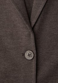 Blazer en tissu gris foncé texturé avec un seul bouton gris portant l'inscription "Street One" pour fermer le devant.