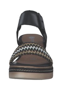 Black leather strap sandals with a woven patterned front, featuring beige, white, and black threads, on a light-colored platform base.
