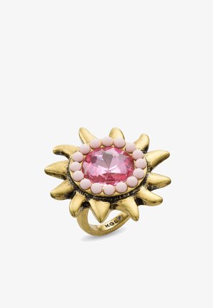 Bague en métal doré en forme de soleil avec un grand bijou rose facetté au centre, entouré de petites perles roses rondes.