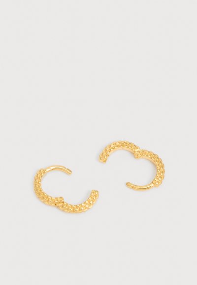 O pereche de cercei mici din aur în formă de cerc, cu un model țesut texturat, expuși pe un fundal alb simplu.