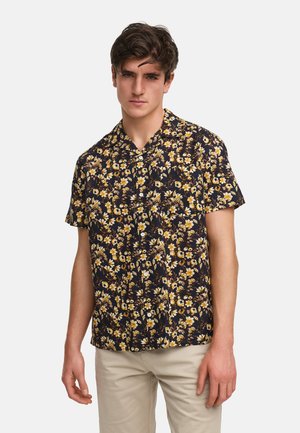 Camicia a maniche corte con un motivo floreale blu navy, caratterizzata da fiori gialli e bianchi. Realizzata in tessuto leggero con vestibilità rilassata.