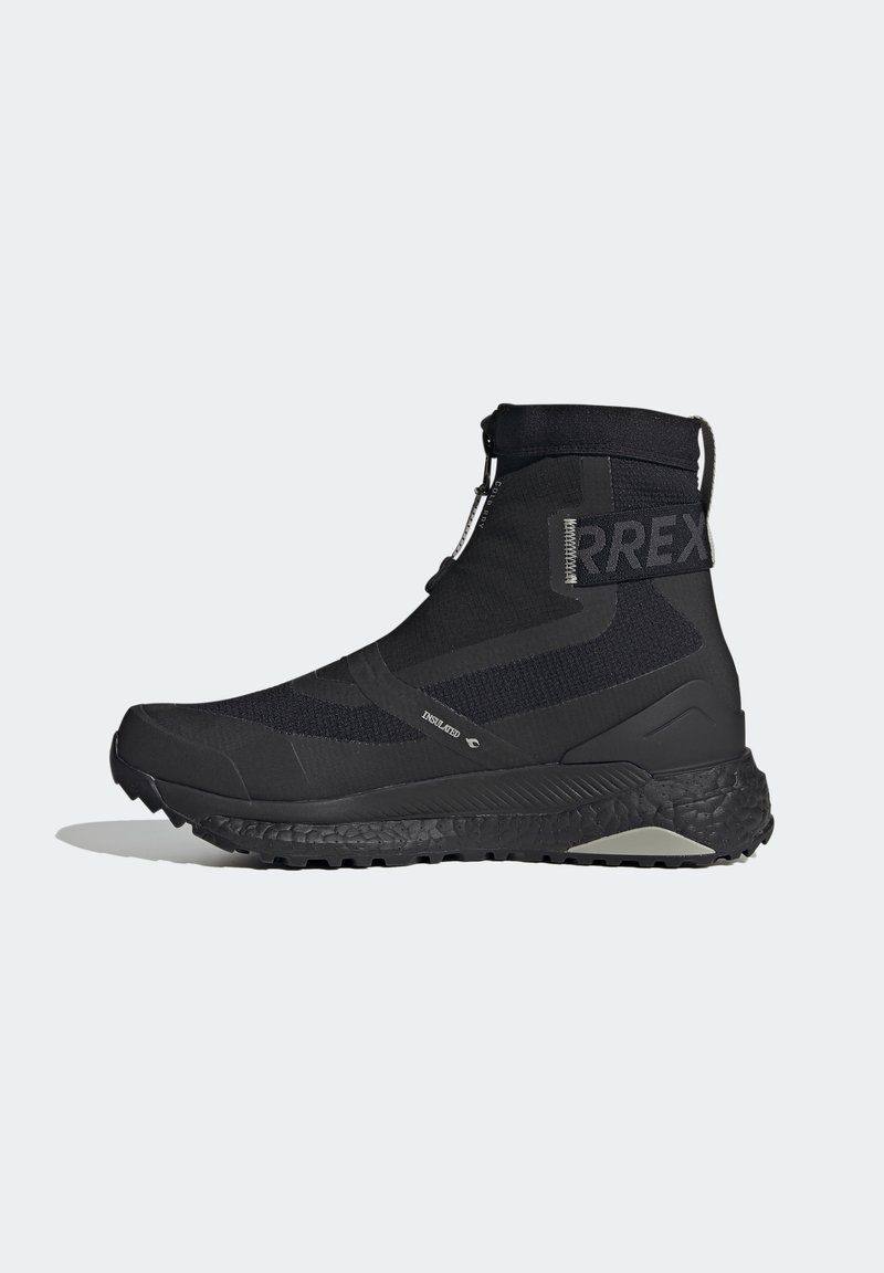 Chaussure de trail running montante isolée noire avec semelle texturée, fermeture éclair et écusson "RREX" sur le côté pour une utilisation extérieure.