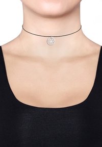 Sorte choker halskæde med en rund sølvvedhæng, der har et geometrisk mønster. Glat tekstur og minimalistisk design.
