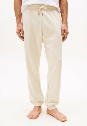 Joggers de algodón beige con cintura ajustable y puños acanalados, y costuras laterales. Textura suave con un corte relajado, adecuado para ropa casual.