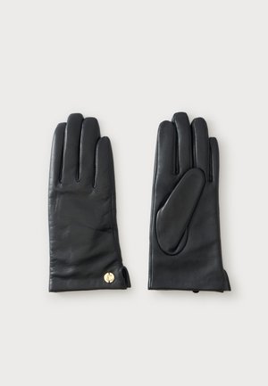 Paire de gants en cuir noir avec détails de couture et petit bouton doré au poignet, présentée sur un fond clair uni.