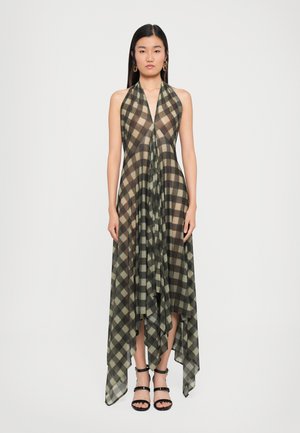 Vestido largo con cuello halter en tela translúcida; presenta un patrón de cuadros en negro y verde oliva; dobladillo asimétrico; combinado con sandalias negras con tiras.