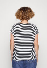 Camiseta de manga corta a rayas en azul marino y blanco, con un escote redondo y un corte relajado, hecha de suave material de algodón.