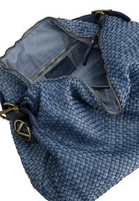 Blauwe geweven leren handtas met een ruime binnenkant, messing rits en contrasterende lichte stoffen voering. Opvallende geweven textuur en verstelbare schouderriem.