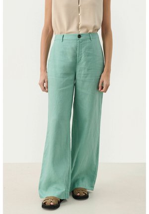 Pantaloni in lino leggeri di colore verde chiaro, a gamba larga, con vita alta e un singolo bottone frontale. Tessuto testurizzato con una finitura liscia.