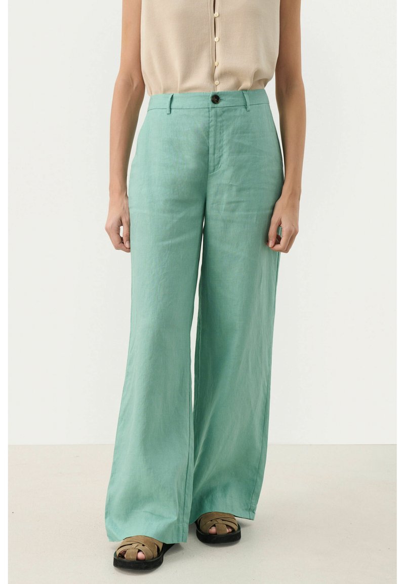 Pantalons en lin vert clair, à jambes larges, avec une taille haute et un unique bouton à l'avant. Tissu texturé avec une finition lisse.