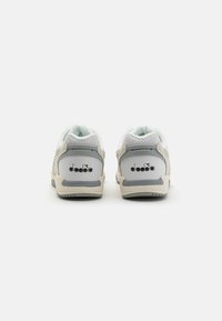 Sneakers bianchi con tomaia in morbida pelle scamosciata e mesh, dettagli grigi e logo sul tallone. Punta arrotondata e colletto imbottito.