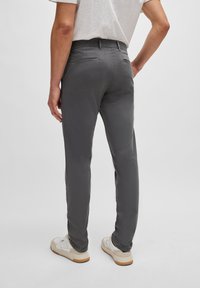 Grå chinos med slim fit, med en mjuk textur, två bakfickor och låg midja. Matchat med vita sneakers.