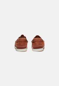 Braune Lederschuhe mit niedrigem Profil, abgerundeter Spitze, weißen Nähten und einer hellen Sohle. Flache Schnürsenkel sind nicht sichtbar.