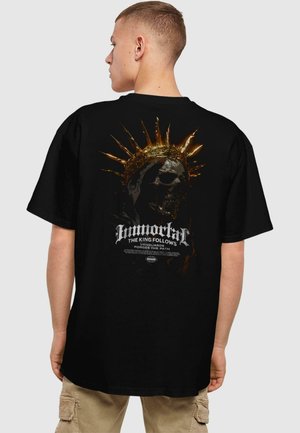 Black cotton t-shirt featuring a graphic design of a skull with a spiked crown on the back. Text in white and gold includes "Immortal" and related phrases.