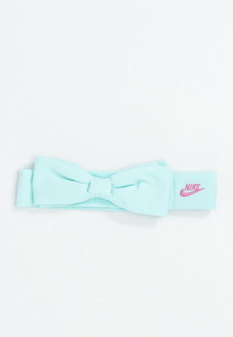Un bandeau en tissu bleu clair avec un détail nœud à l'avant et un logo Nike rose sur le côté. Matériau lisse et élastique.