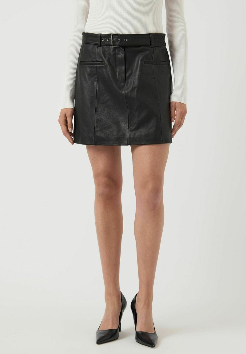 Sort skinnskjørt i svart med belte, med frontlommer, glatt tekstur og en tettsittende silhuett.