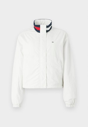 White cropped jacket with a high collar featuring navy, red, and white striped accents, elastic cuffs, and snap button closure.